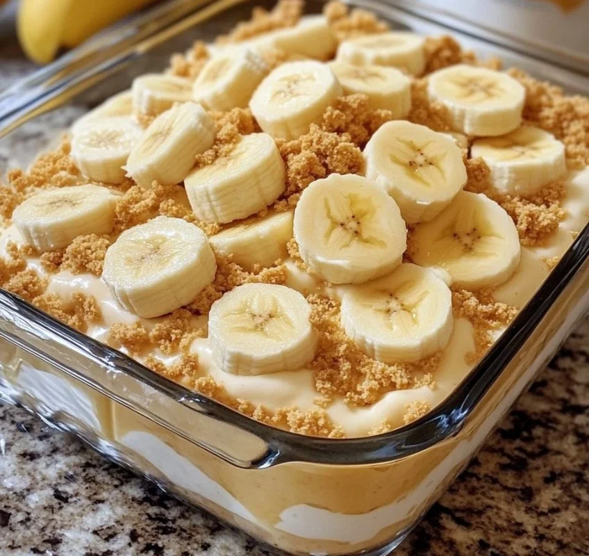 Delicious banana pudding dessert topped with creamy whipped cream and sliced bananas.